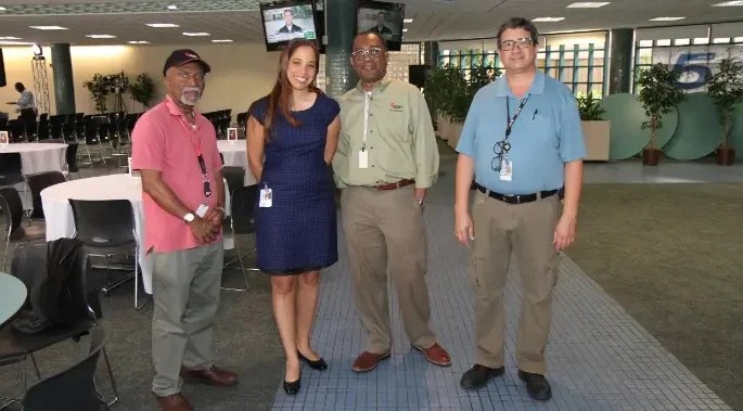 Alexandra Hill stands with three other Beckman Coulter Life Sciences employees in an office.