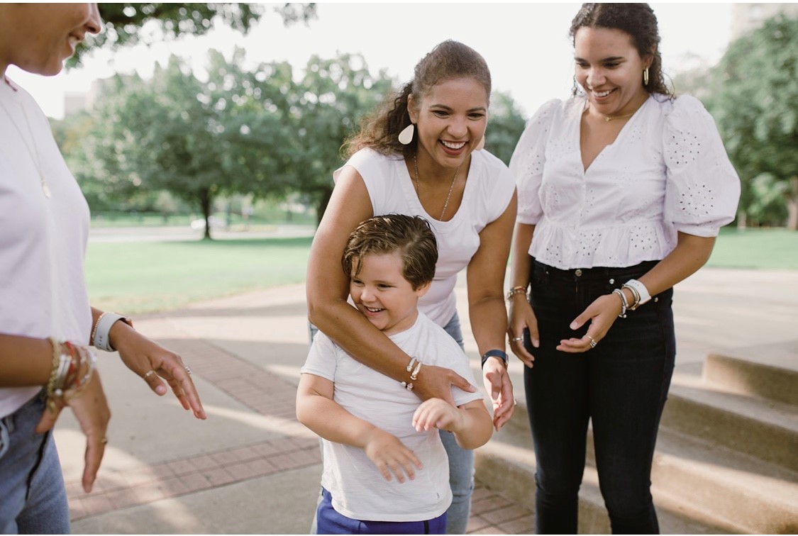 Shwanna Tauriac stands candidly with her family outside while wearing matching outfits.