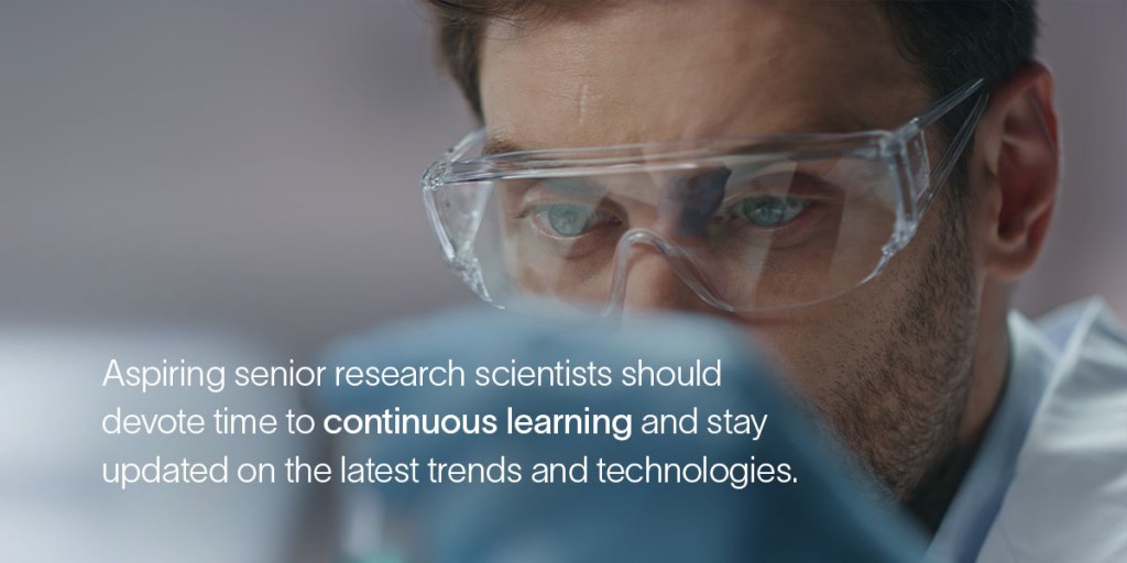A senior research scientist wearing safety glasses closely examines something 