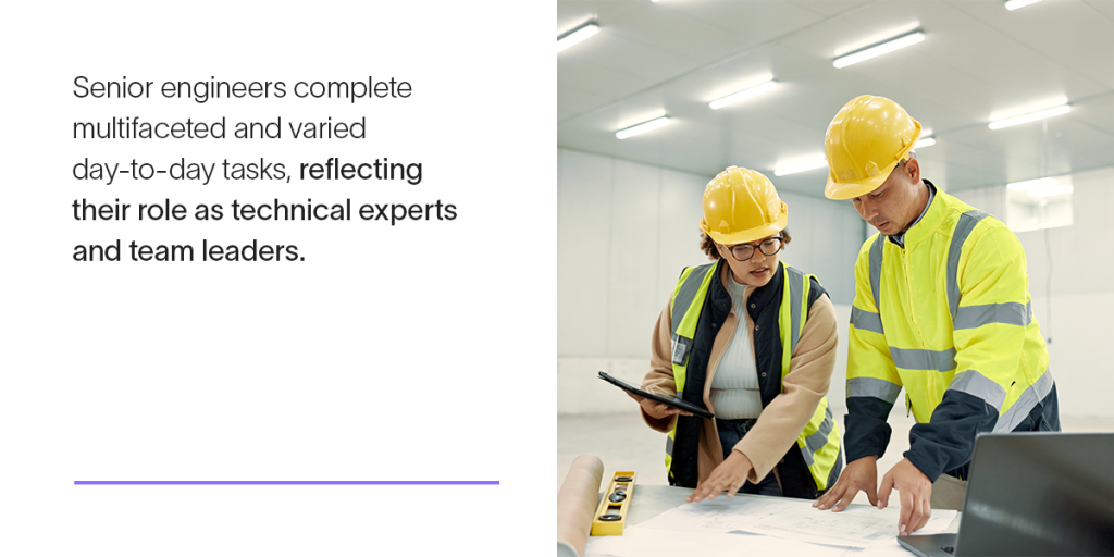 Two engineers in personal protective equipment look at technical documents