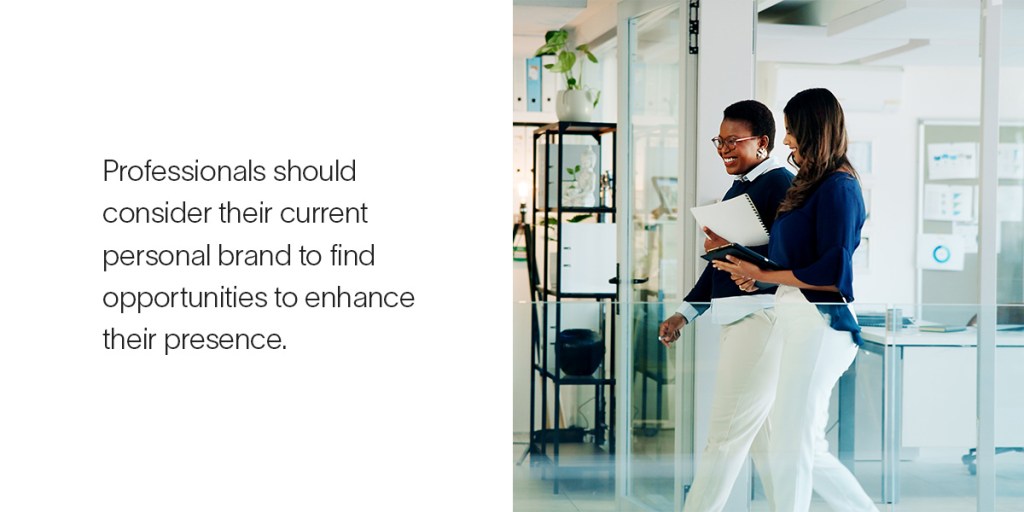 Two women walk together in a well lit office