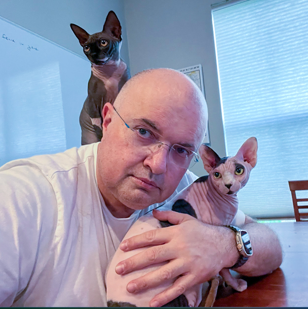 igor zeltzer posing with his two hairless cats