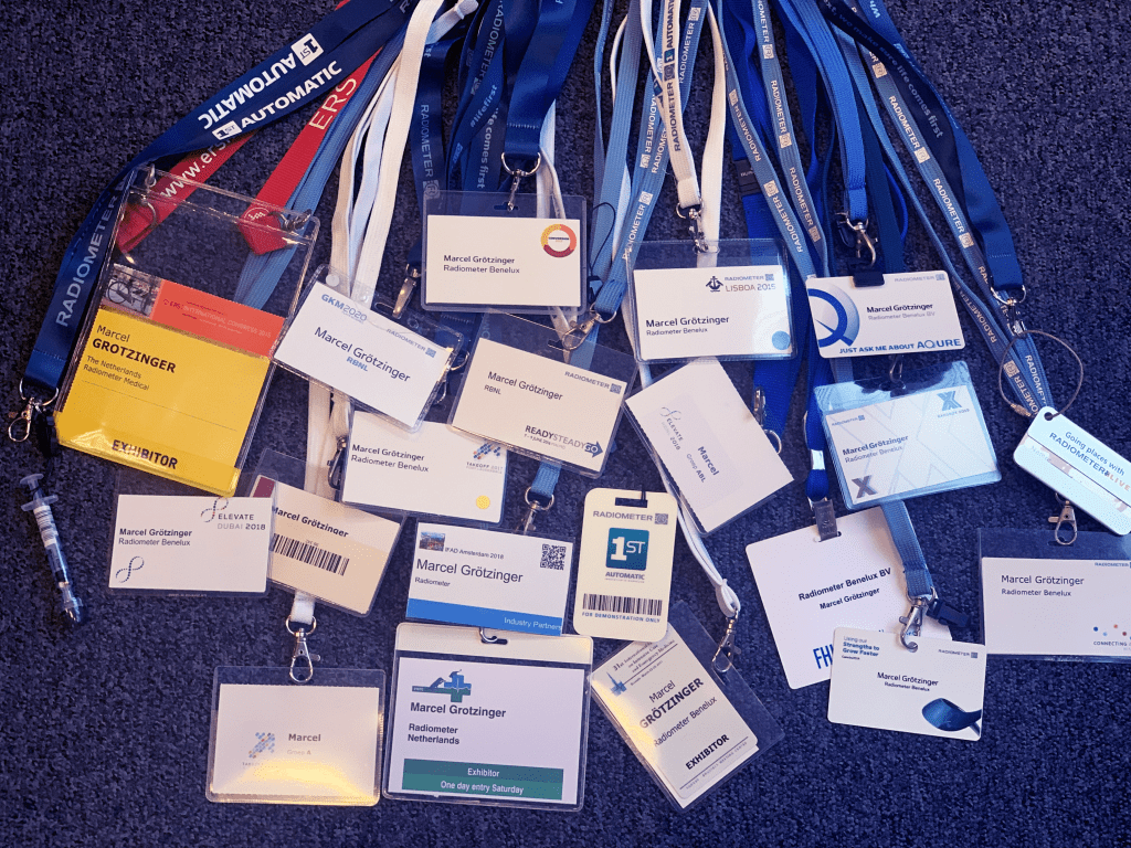 a large group of event badges on lanyards, all with Marcel Grotzinger's name
