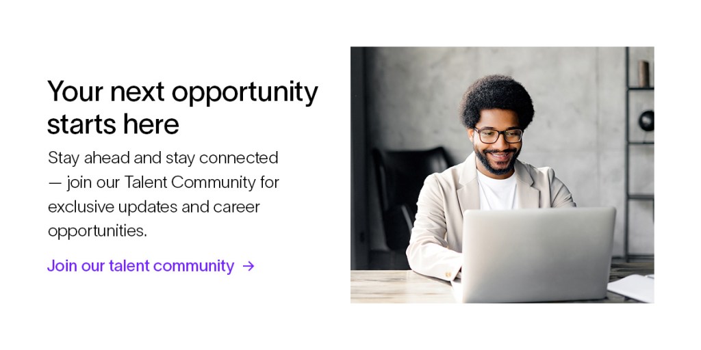 A young professional smiles and types on a laptop