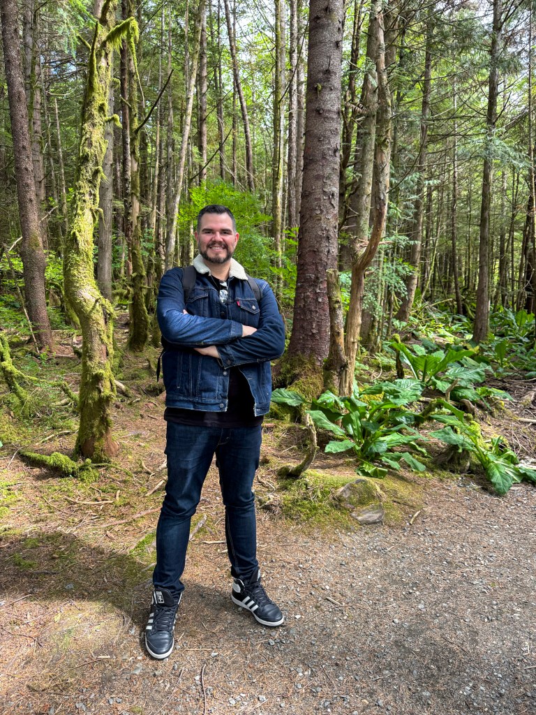 Oliver standing in a wooded forest