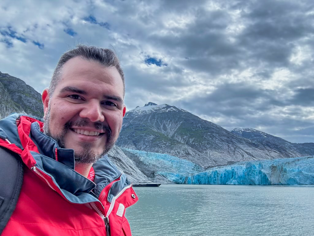 oliver crespo posing in front of a glacier in Alaska